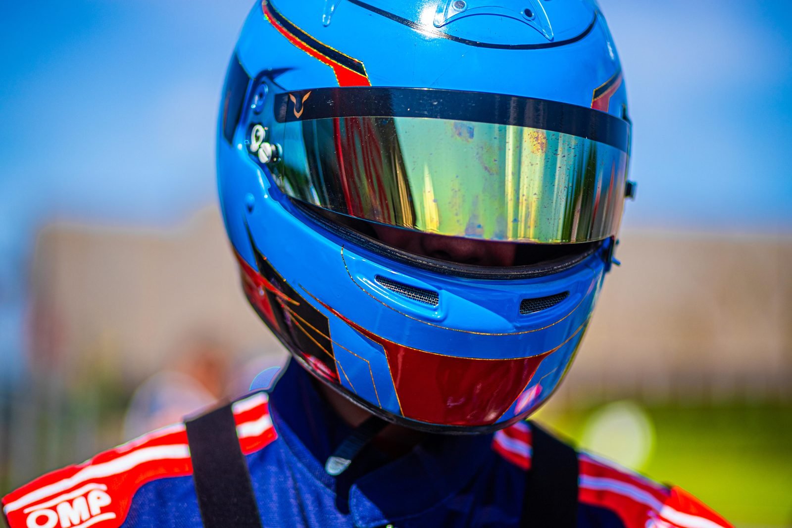 Portrait of Samuel Uváček, karting driver, in a blue helmet with a mirrored visor